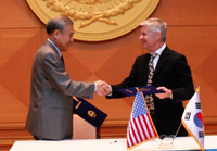 Hanyang Cyber University Chancellor Dr. Byun Chul Hyu shakes hands with Anaheim University Dean Dr. David Nunan 